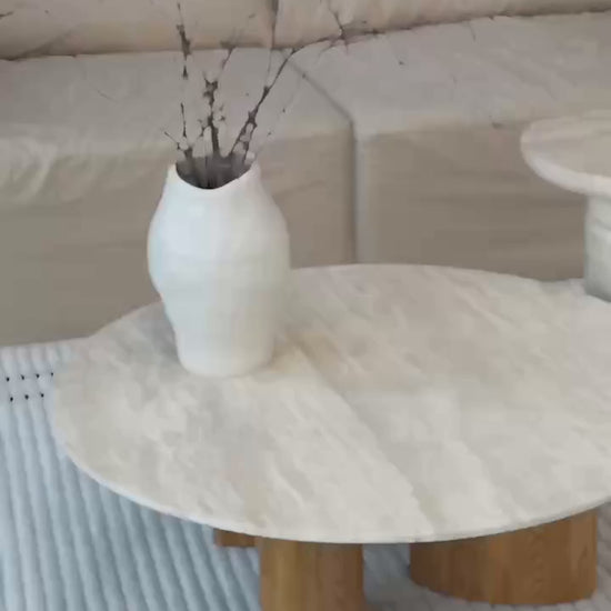 a coffee table with a natural travertine top and wooden base, beige colour
